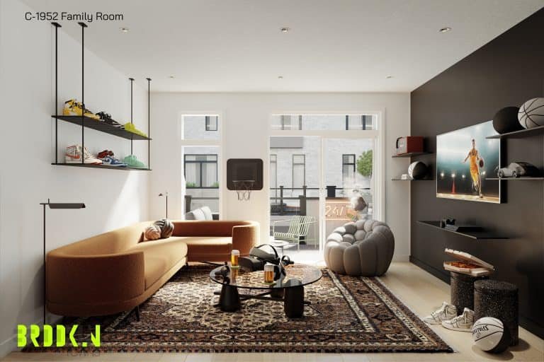 A modern family room in Brooklin Towns features a brown sofa, patterned rug, and glass coffee table. Wall-mounted shelves display sneakers. A plush beanbag and TV add comfort. Sunlight streams through large windows, illuminating the space where a basketball sits on the floor.