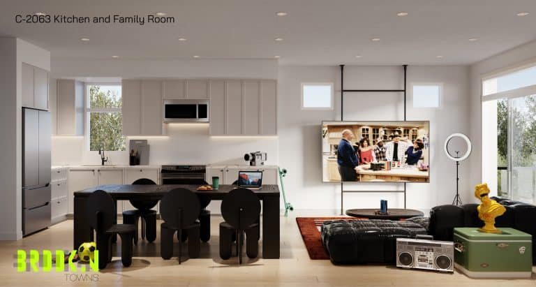 A modern kitchen and family room with minimalist design. The kitchen has sleek white cabinets and a dark dining table with four chairs. The family room features a sectional sofa, a TV, and a ring light. Large windows let in natural light. A logo reads "Brooklin Towns.