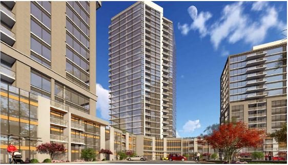 A modern high-rise apartment complex with three buildings of varying heights under a clear blue sky with light clouds stands as a prime example of the new condos in GTA. The complex features glass exteriors and balconies, red foliage trees, a few cars, and people visible at ground level.