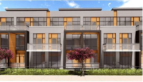 A modern multi-story building with a gray facade features large glass windows, balcony railings, and wooden accents. The entrance is framed by metal and glass balconies on each level. Trees with lush purple foliage and grassy landscaping are in front. Ideal for those seeking new condos in GTA.