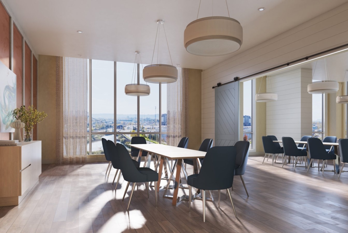 A modern conference room with large windows allowing natural light to fill the space. The room features a long wooden table surrounded by dark blue chairs. Three large, round pendant lights hang from the ceiling. Ideal for meetings about new condos in GTA, the room has light wood flooring and minimalistic decor.