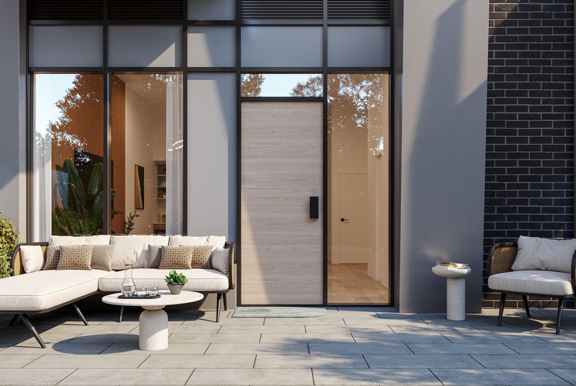 Modern patio with stylish outdoor furniture including a sofa and chairs, complemented by potted plants that add a touch of greenery. Adjacent to tall black-framed windows and a wooden door on a