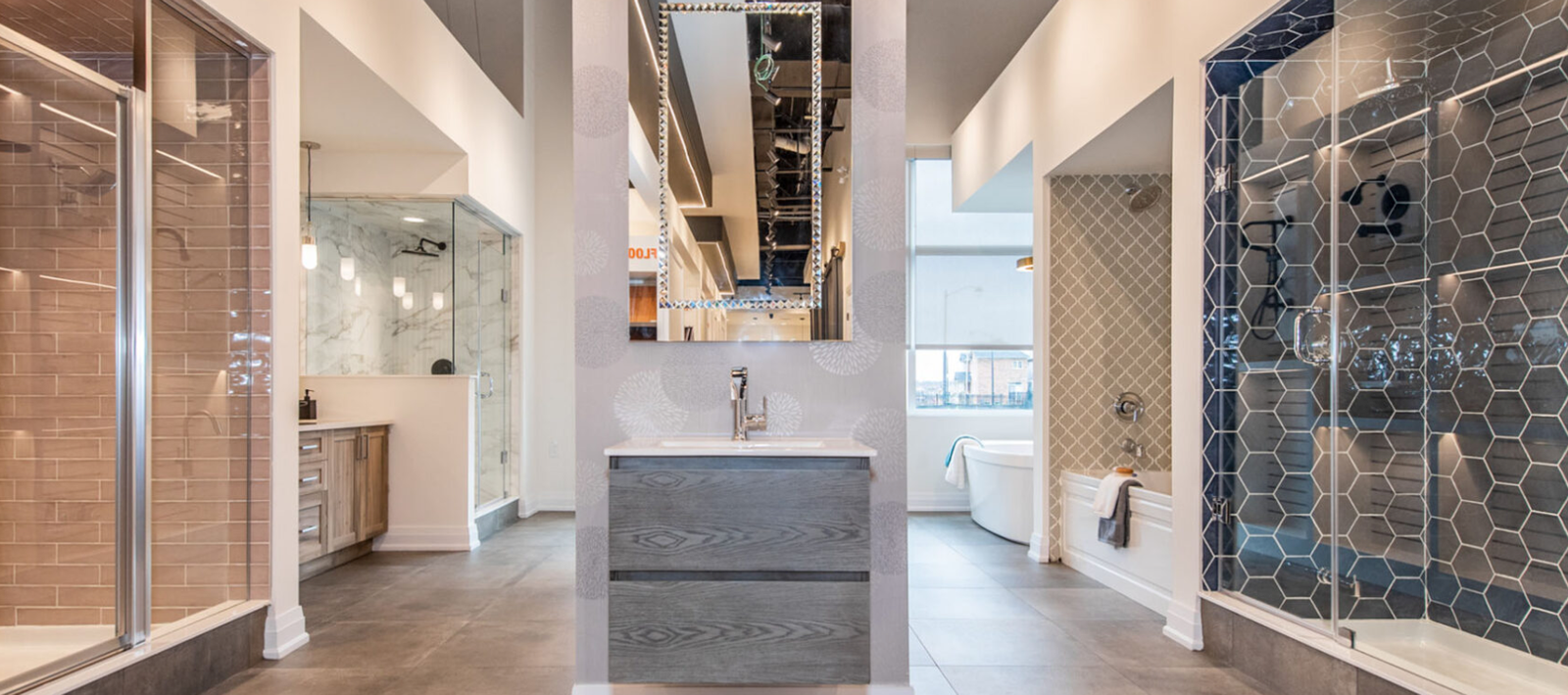 A stylish showroom display featuring modern bathroom designs, perfect for pre-construction homes. The centered vanity with a rectangular mirror is flanked by diverse shower and bathtub setups showcasing contemporary tiles, fixtures, and finishes. The overall look is sleek and sophisticated.