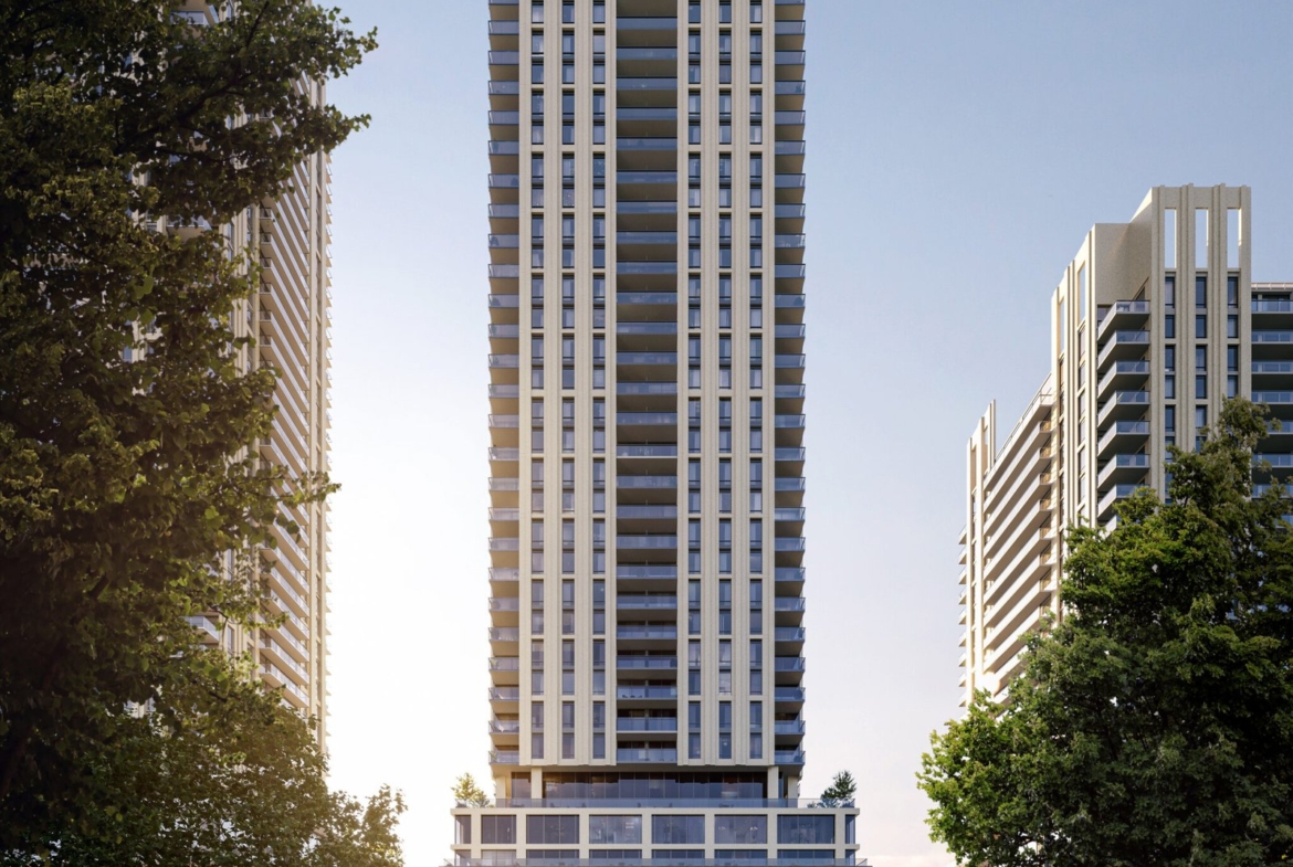 A modern high-rise residential building stands prominently in an urban setting, featuring new condos, bathed in sunlight with a glimpse of lush greenery.