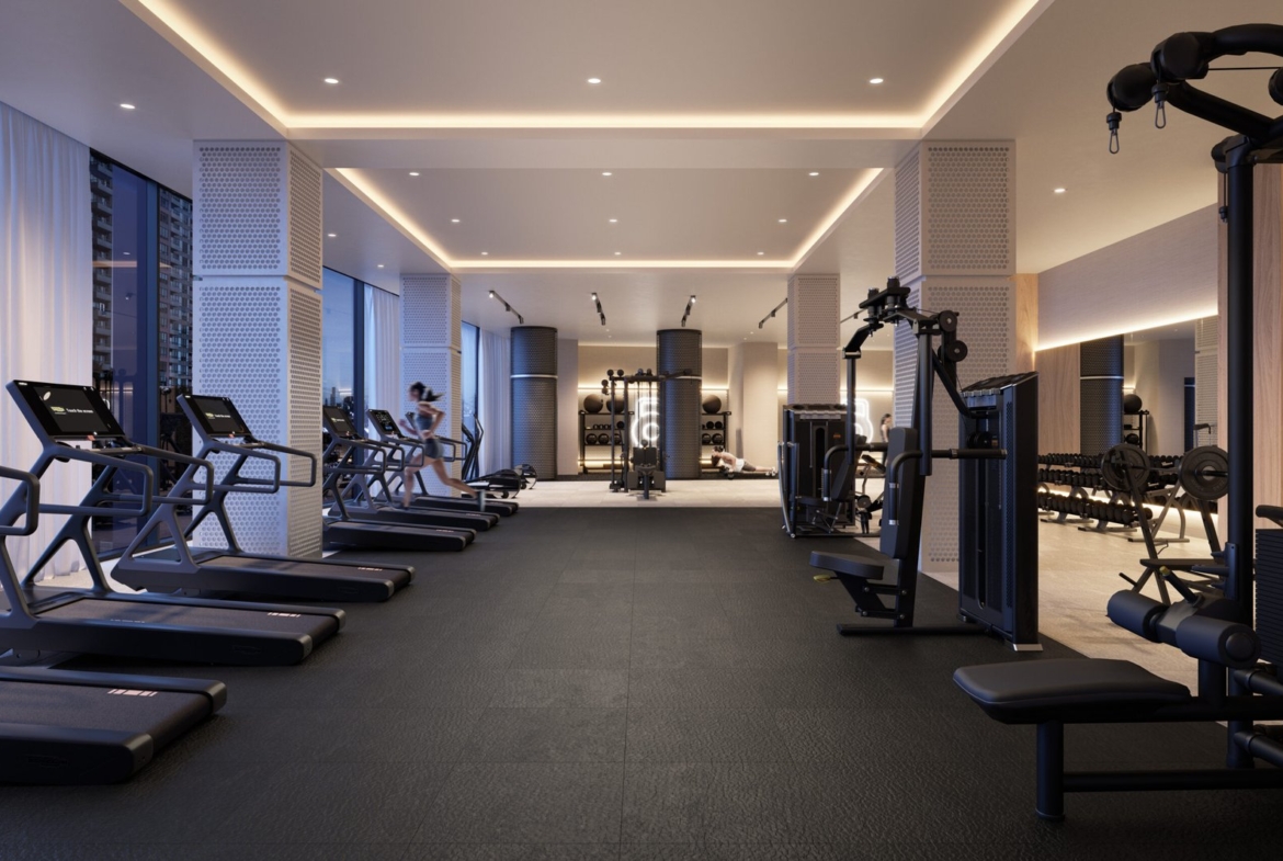 Modern Gagan Bector gym interior with treadmills, weights, and exercise equipment; featuring ambient lighting and clean design. One person visible, using equipment in the background.