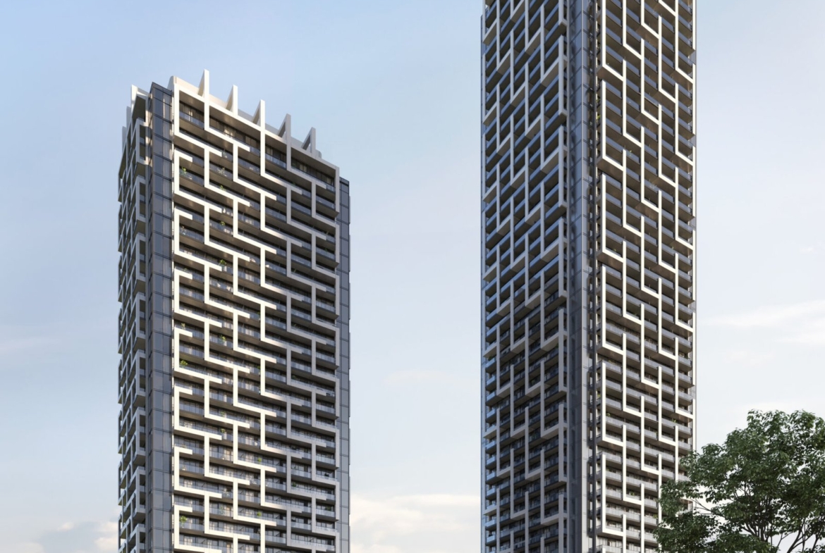 Two tall buildings with trees and grass.