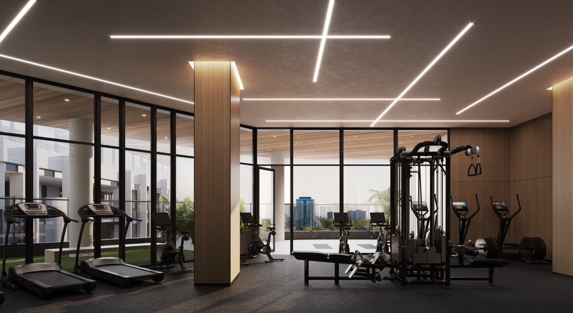A gym room in a pre-construction building with a view of the city.
