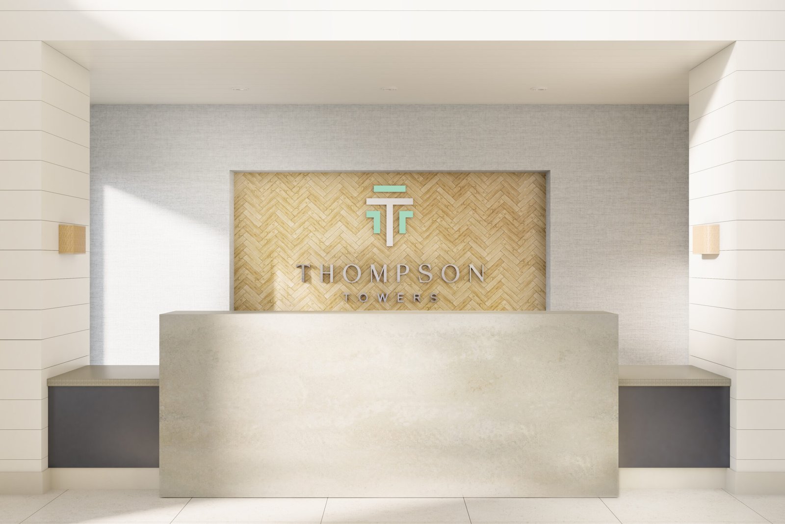 A modern reception desk with a light gray counter stands in front of a wall featuring a wood herringbone pattern. Above the desk, the text "THOMPSON TOWERS" is displayed alongside a stylized "TT" logo. The area, well-lit with neutral tones and minimalist design, highlights the appeal of new condos in GTA.
