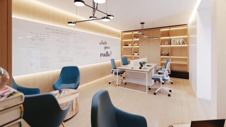 A modern office space within Motto Condos features a whiteboard wall covered in notes and equations, a central table with chairs, and blue armchairs around a small wooden table. Shelves with books and plants are in the background, while the text "What's your model?" adorns the wall.