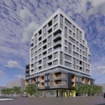 Motto Condos is a modern multi-story building with a unique geometric design, featuring protruding balconies and large windows. It stands on a street corner with a clear sky and scattered clouds above, surrounded by a few trees and vehicles nearby.