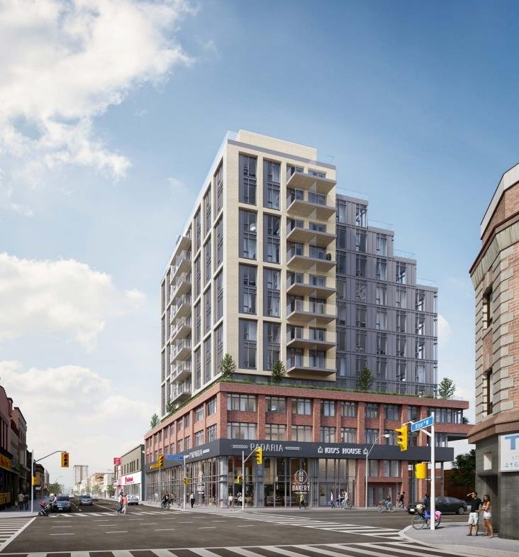 A modern multi-story building with a combination of glass and brick exterior stands at a street corner. The ground floor has shops and a restaurant with outdoor seating. People are walking on the sidewalk, cars are driving on the street, and nearby new condos in GTA add to the vibrant atmosphere. The sky is partly cloudy.