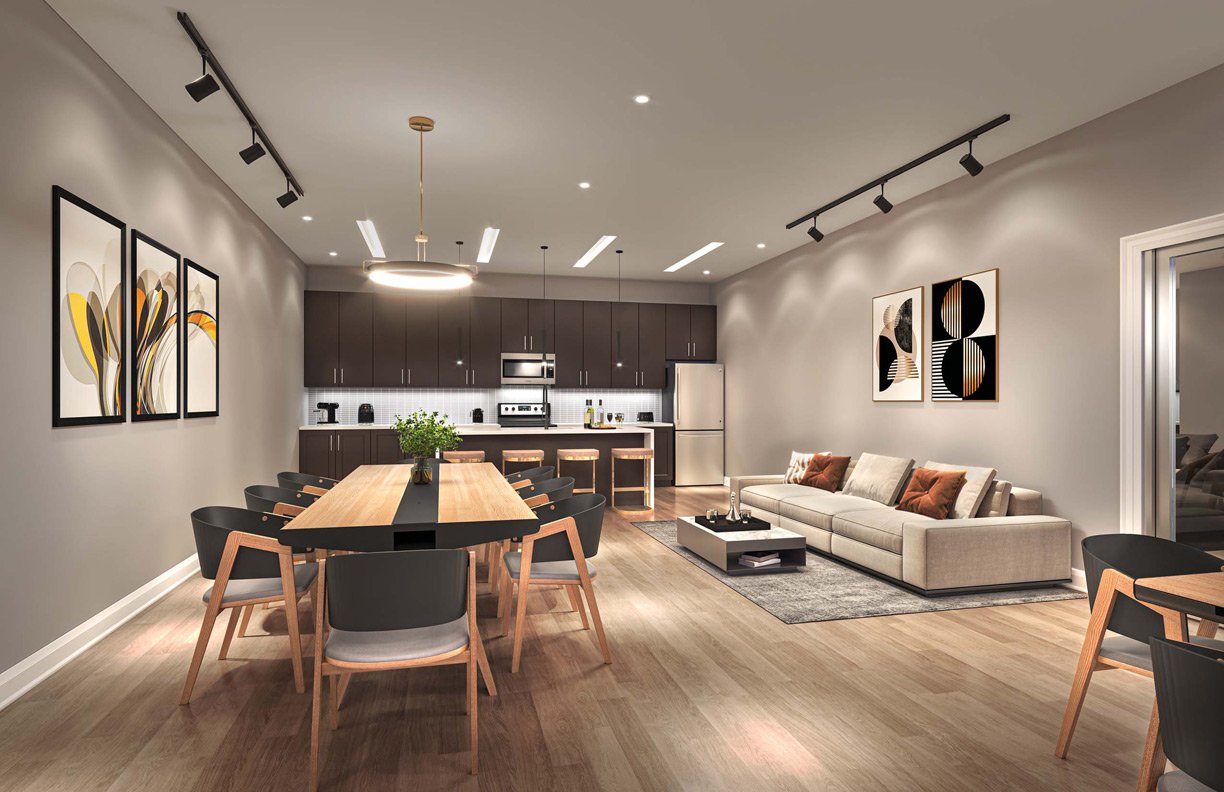Modern open-plan living space featuring a kitchen with dark cabinetry, a dining area with a large wooden table, and a lounge with beige sofa, all under warm ambient lighting in New Condos