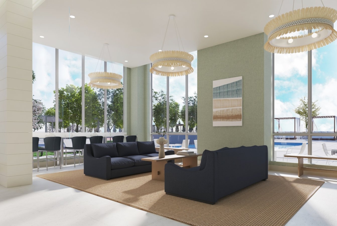 A modern lounge area in one of the stunning new homes in GTA features large windows revealing a pool outside. Inside, two dark blue sofas sit on a beige rug with a wooden coffee table between them, and three contemporary chandeliers hang from the ceiling. Bar stools line a counter near the windows.