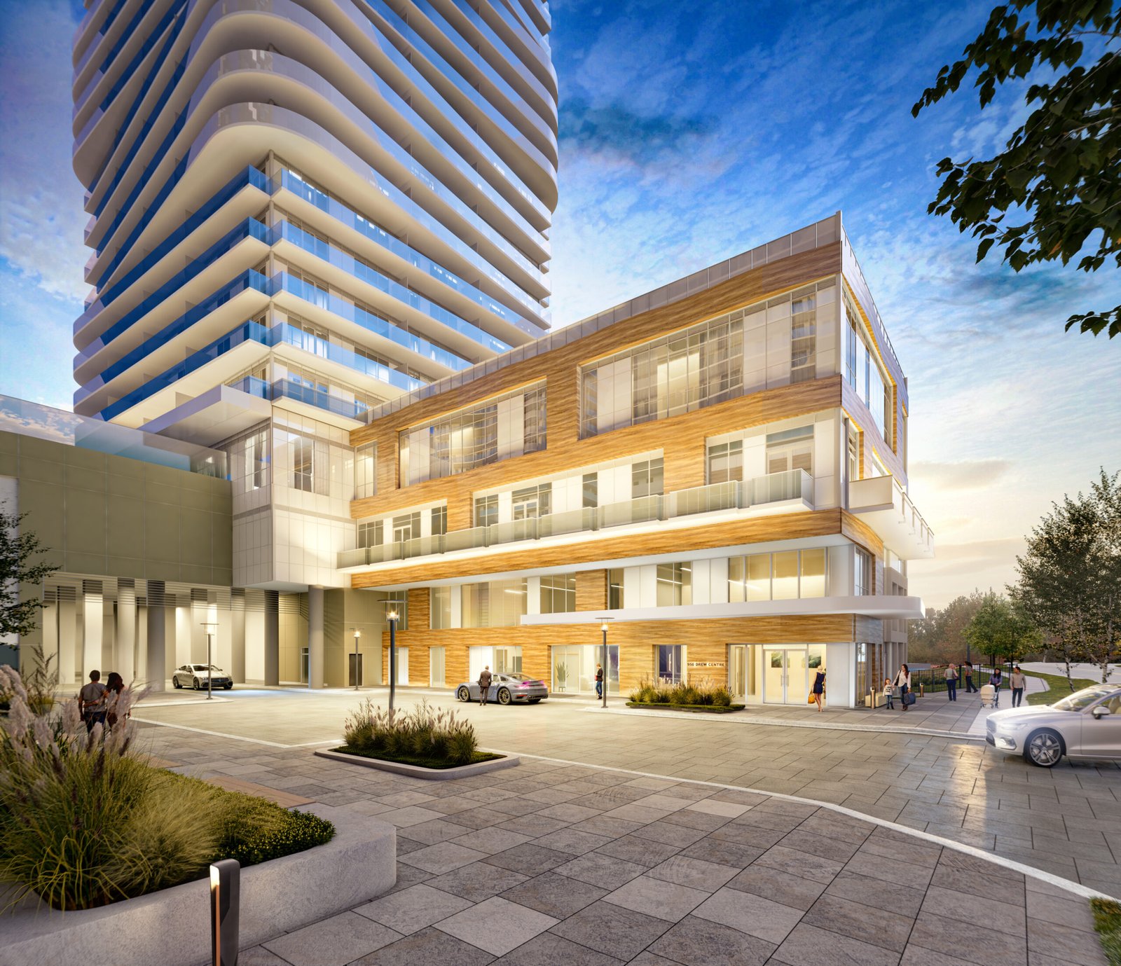 An elegant, modern building complex with a sleek white tower featuring curved balconies and a shorter, brick-patterned adjacent building. The foreground showcases a clean, spacious plaza with landscaped greenery and some people and cars scattered about—an enticing option for new condos in GTA.