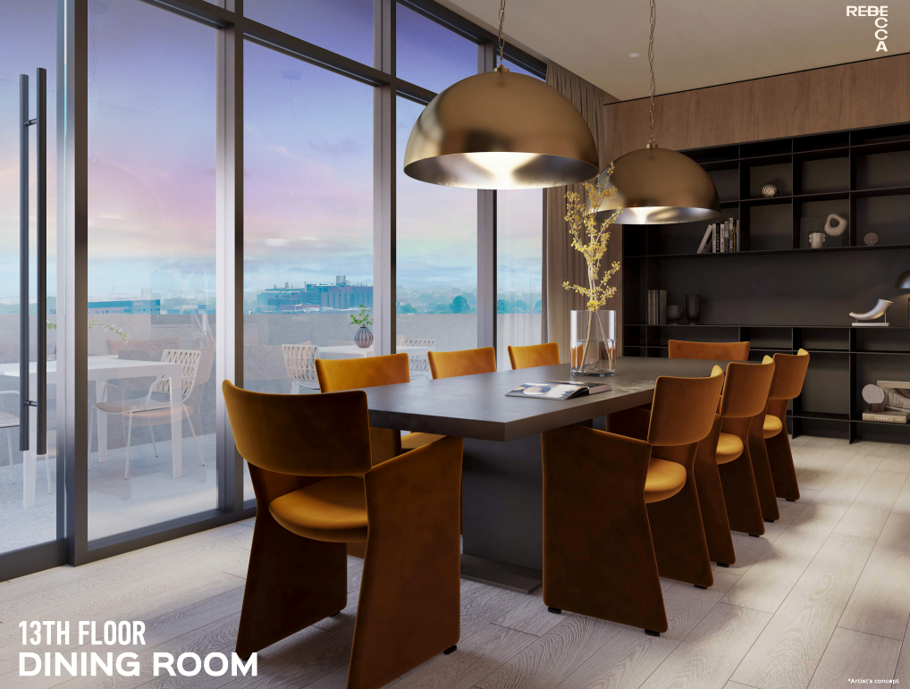 A modern dining room on the 13th floor of new homes in GTA features a long table with eight brown leather chairs, illuminated by two large pendant lights. Floor-to-ceiling windows offer a cityscape view. A built-in black shelving unit completes the contemporary design.
