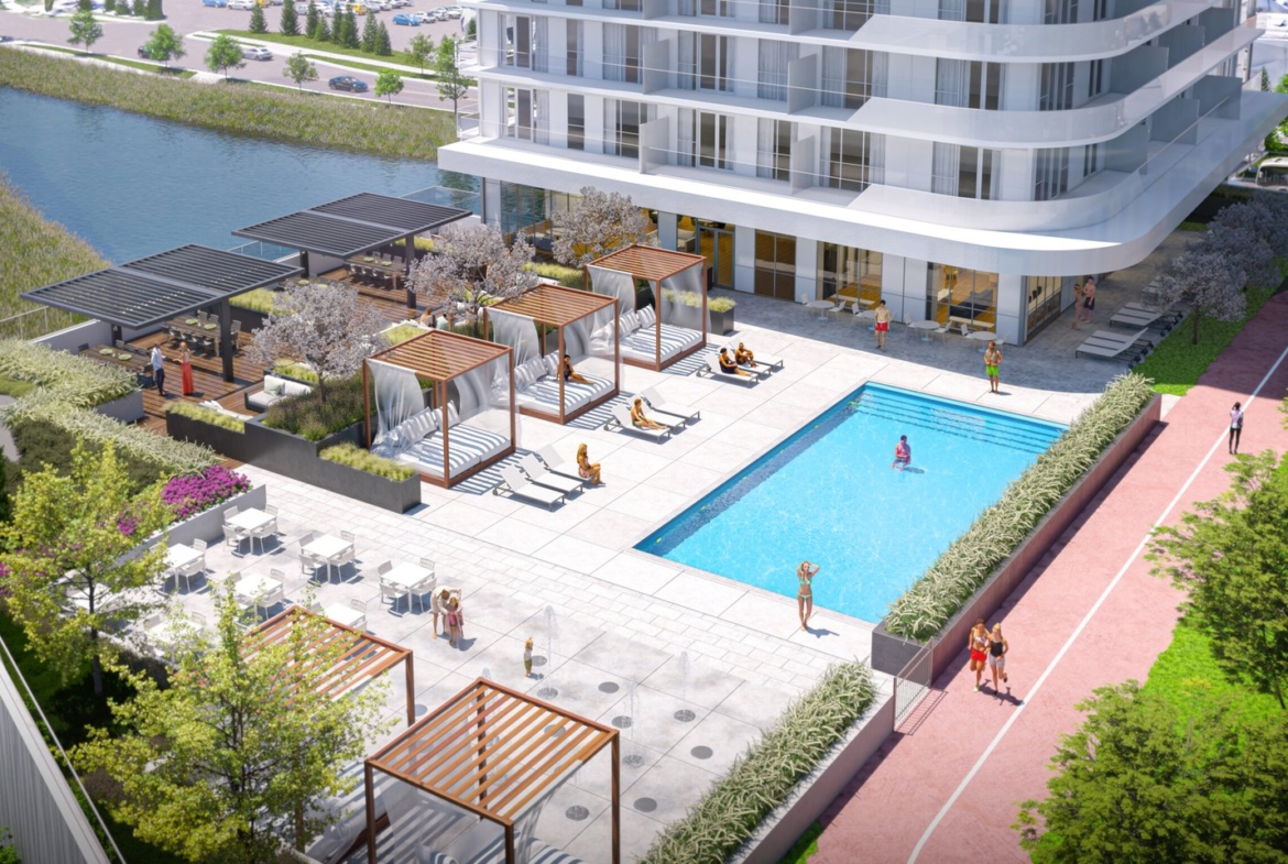 A modern, high-rise residential complex features an outdoor swimming pool, poolside cabanas, outdoor seating, and landscaped gardens. Residents relax by the pool and enjoy the amenities of these new homes in GTA, with a canal and parking lot visible in the background.