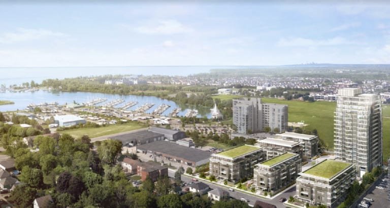 Aerial view of The Landing Condos, a modern housing development near Whitby Harbour. Surrounded by lush greenery and residential areas, the complex includes multiple multi-story buildings with green roofs. The marina features numerous docks and boats, set against a backdrop of a large body of water.