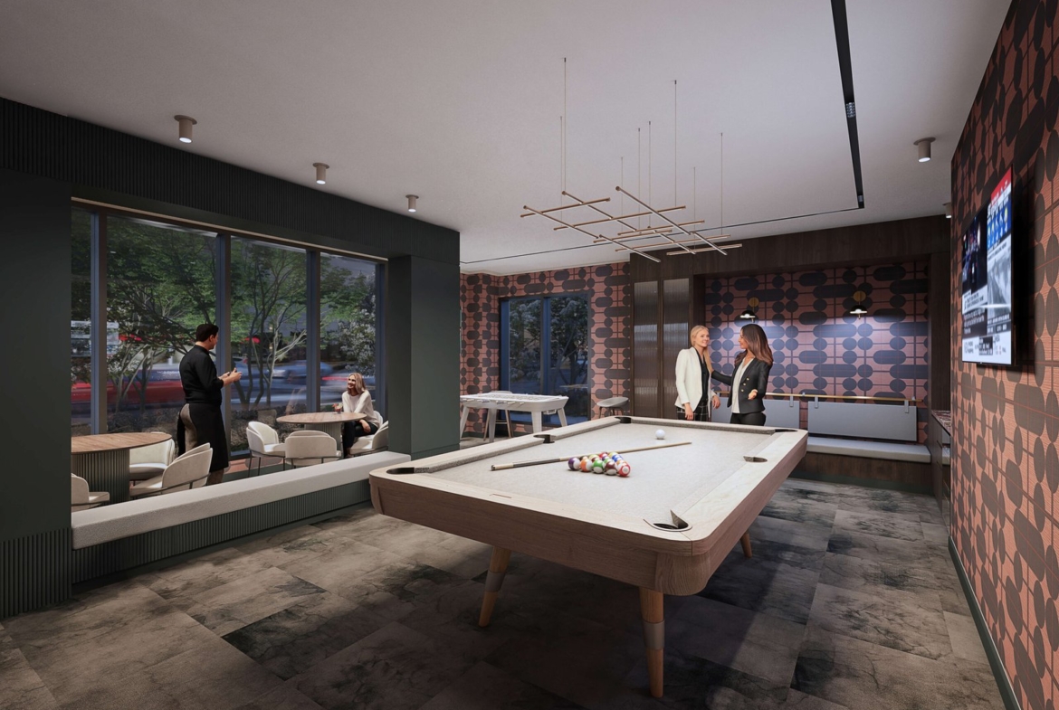 A modern game room in new homes showcases two people by a pool table and two others seated by a window. The room, perfect for pre-construction homes, is decorated with patterned walls, a TV, and a unique ceiling light fixture.