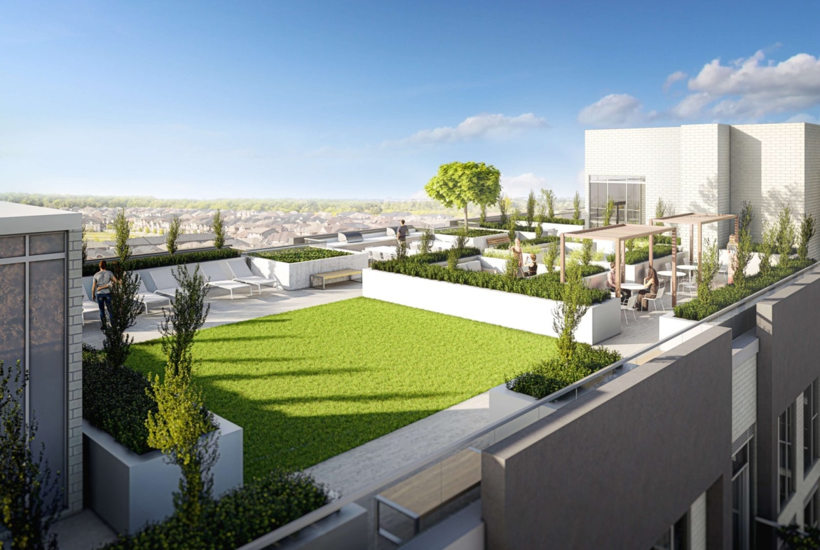 A rooftop terrace with modern design showcases a green lawn, white planters, and seating areas enveloped by lush greenery. A few people relish the sunny day under clear skies, enjoying a panoramic city view. This serene space is part of pre-construction homes offering luxury and tranquility.