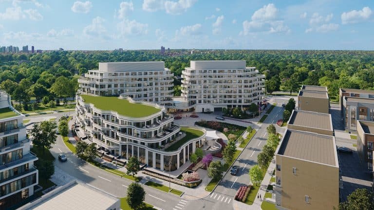 Aerial view of new condos in a modern residential complex showing two large buildings with curved designs, lush green terraces, and surrounded by paved streets.