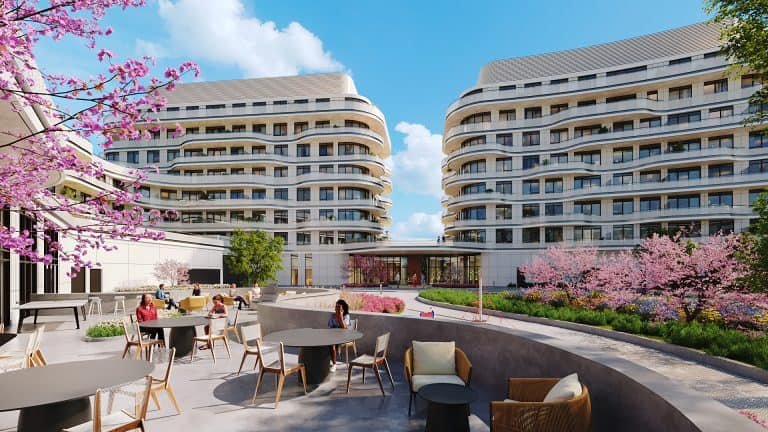 A digital rendering of modern courtyard with curved residential buildings showcases new condos and Gagan Bector. People sit at tables under blossoming pink cherry trees, enjoying the sunny outdoor setting.