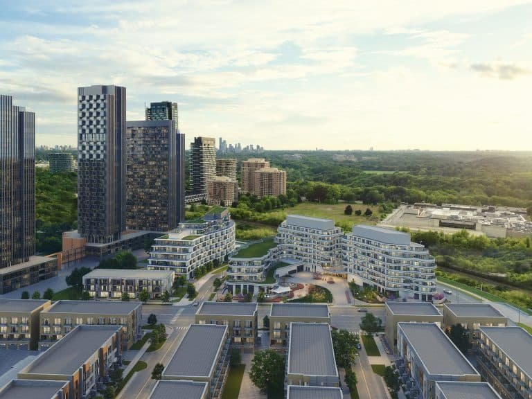 Aerial view of new homes in GTA showcasing a blend of high-rise buildings and pre-construction homes surrounded by greenery under a clear sky.