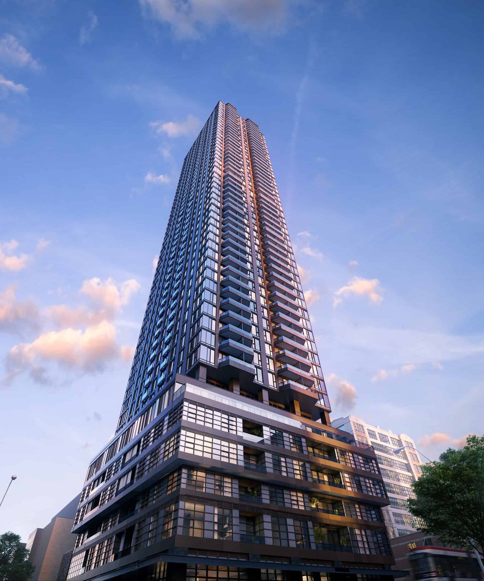The sleek, glass exterior of the tall, modern skyscraper stands out against a blue sky with soft clouds. Its prominent angular design echoes the innovative architecture of new homes in Brampton. At its base, trees and a vehicle enhance the sense of scale.