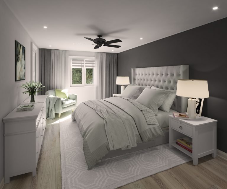 A modern bedroom in one of the new homes in GTA features a large bed with a grey padded headboard and light grey bedding. Twin nightstands flaunt lamps, while a green armchair sits by the window under a ceiling fan. The room's dark and light grey walls are complemented by a dresser and potted plant.