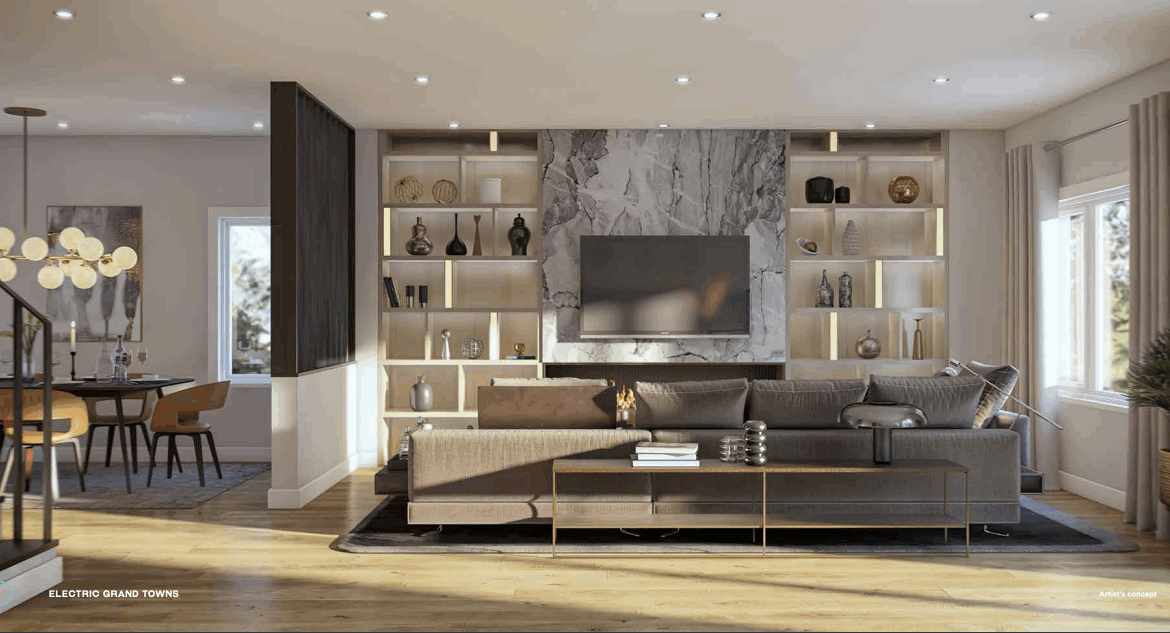 A modern living room with a large brown sectional sofa faces a wall-mounted TV. The wall showcases built-in shelves with decorative items. Bathed in natural light from windows and recessed ceiling lights, it exudes warmth. A dining area is visible to the left, ideal for those considering new condos in GTA.
