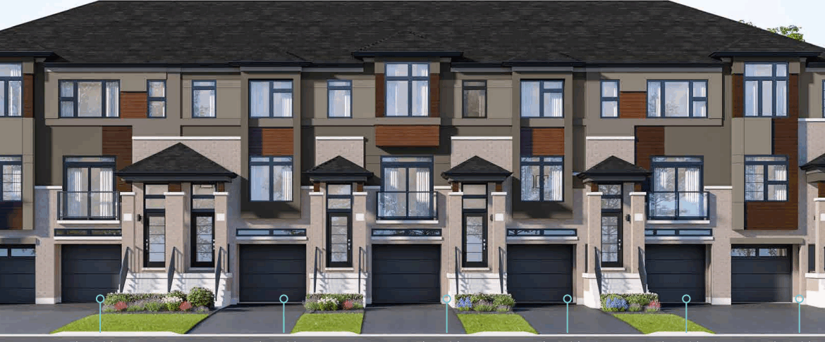 A row of new homes with dark roofs, large windows, and varied paneling in neutral shades. Each unit features a black garage door and a small landscaped front yard with grass and flowers. Trees provide a lush backdrop, enhancing the appeal of this modern community.