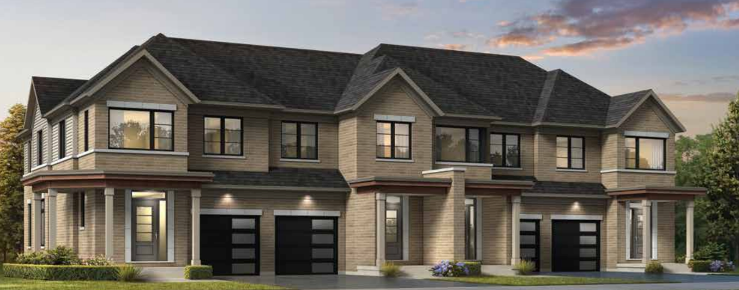 A modern townhouse complex at dusk, featuring neutral-toned brickwork, multi-pane windows, and dark garage doors. These new homes in Brampton have units with small shrubs and lawns in front, under a partly cloudy sky.