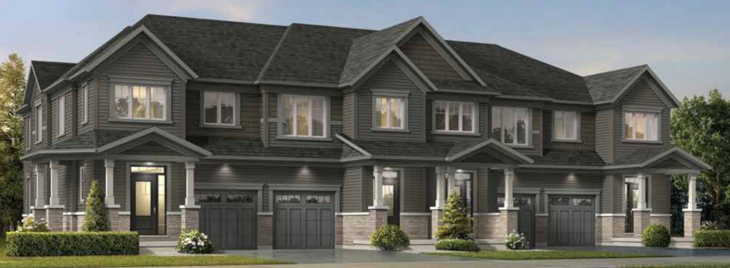 A modern townhouse complex in Brampton with four connected units, each boasting a garage, a front porch, and multiple windows. The exterior showcases a gray and stone color scheme with small shrubs and trees in front. The clear sky suggests it's a sunny day—ideal for new home seekers.