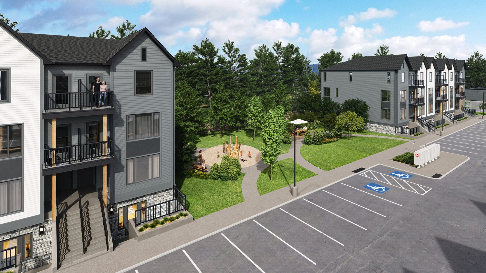 A birds-eye view of a modern apartment complex featuring multiple three-story buildings showcases new homes. A small park with a playground is situated between the buildings. In the foreground, a parking lot includes marked accessible spaces, while trees border this inviting area.