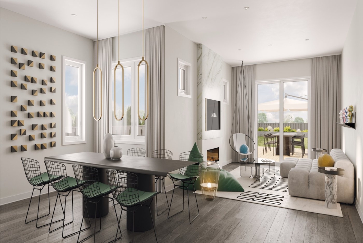 A modern family and dining room showcases a large dining table with black chairs, a light grey sofa adorned with cushions, and a wall-mounted TV. Decorative wall art, pendant lights, and large windows enhance the ambiance. Perfect for new homes in vibrant communities like Brampton.