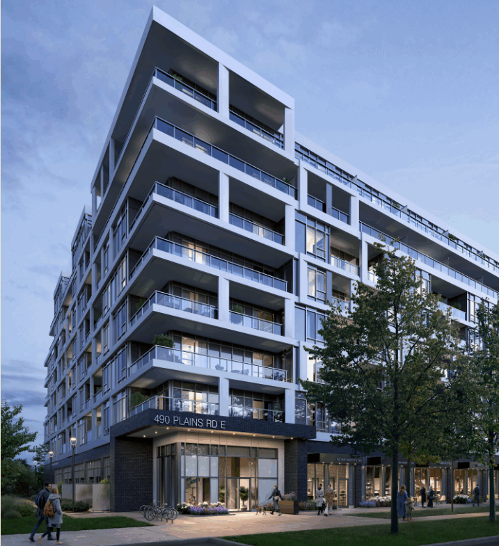 A modern multi-story apartment building at twilight features numerous balconies and large windows, showcasing new homes with contemporary design. The address "490 Plains Rd E" is visible on the facade, surrounded by trees and a bike rack. The sky is partly cloudy, adding to the serene streetscape.