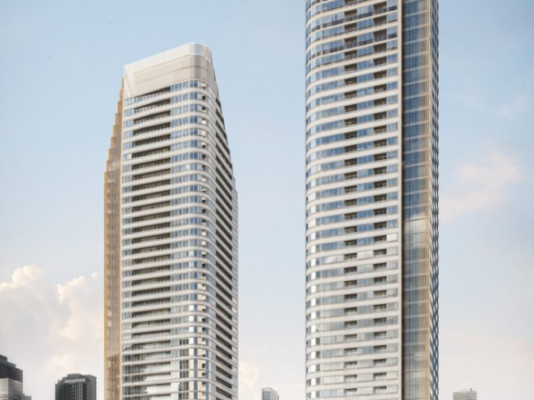 Two modern high-rise buildings, Park Place VMC condos, with sleek, curved designs stand side by side against a clear sky. Surrounded by other skyscrapers and greenery at their bases, the facade reflects light, highlighting the vibrant urban setting.