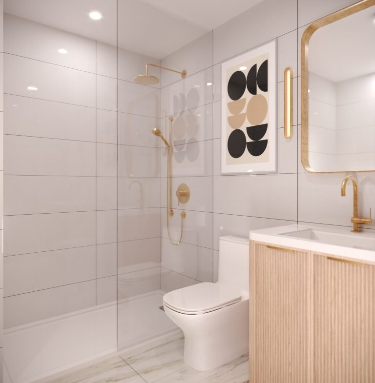 A modern bathroom in VMC Condos features light gray tiles, a gold showerhead, and a matching faucet. A framed abstract artwork adorns the wall, while a mirrored cabinet sits above the wooden vanity. The marble-patterned floor adds elegance to this Park Place residence.