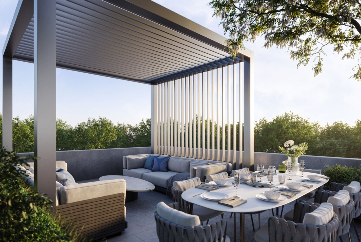 A modern outdoor patio at Mile & Creek Condos features a sleek pergola, a comfortable seating area with cushions, and a dining table set for six. Surrounded by lush greenery, the serene scene is beautifully illuminated under a clear sky.