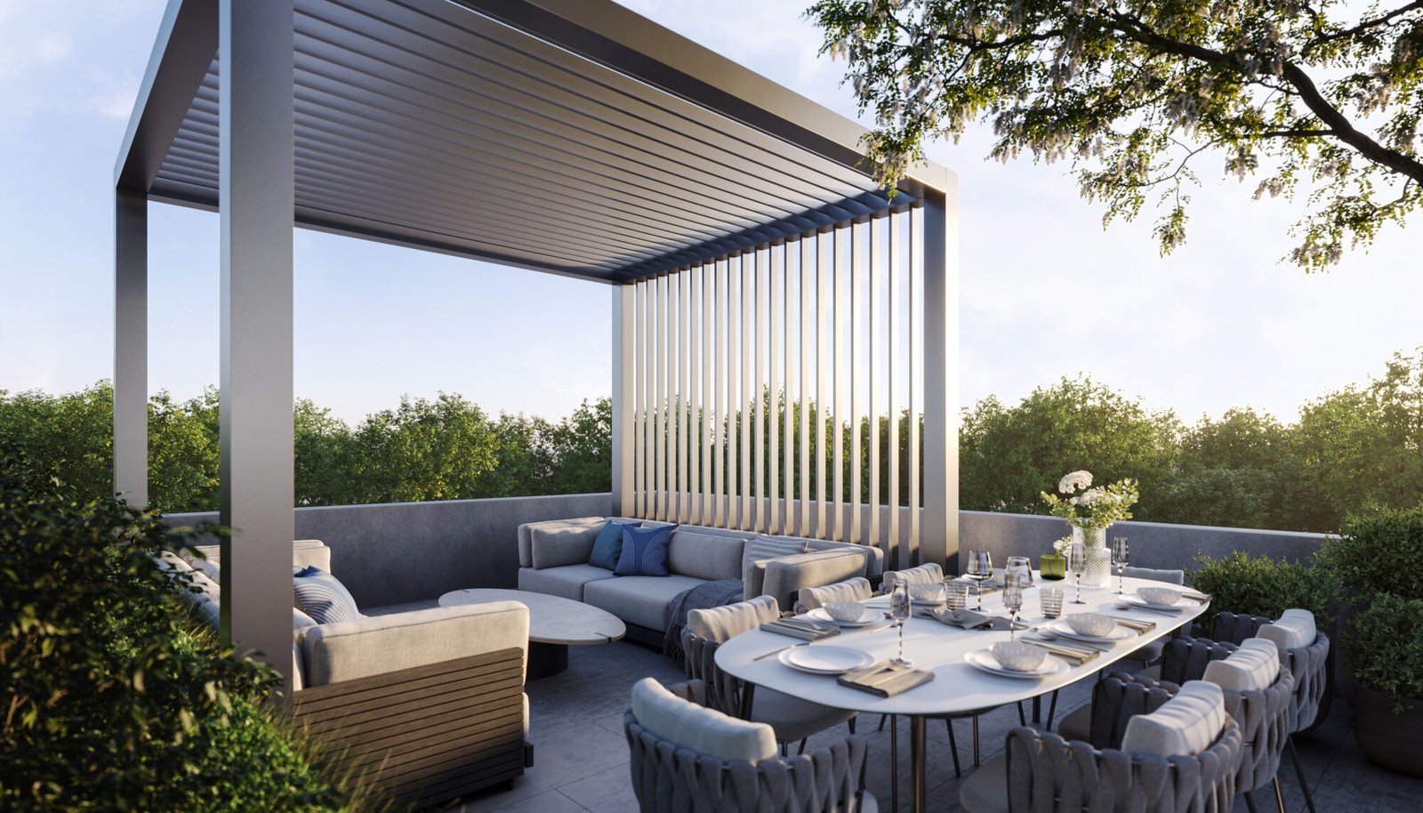A modern outdoor patio at Mile & Creek Condos features a sleek pergola, a comfortable seating area with cushions, and a dining table set for six. Surrounded by lush greenery, the serene scene is beautifully illuminated under a clear sky.