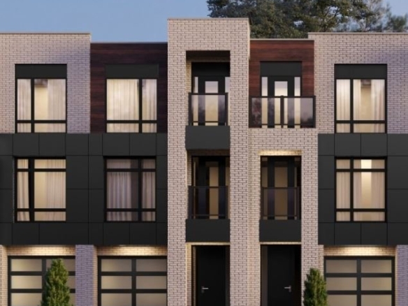 Nestled in the charming Ravine Towns, this modern three-story building with a flat roof showcases large windows and dark panels against light brickwork. Two entrances invite you in, flanked by small shrubs. A clear sky and partial trees complete the picturesque setting.