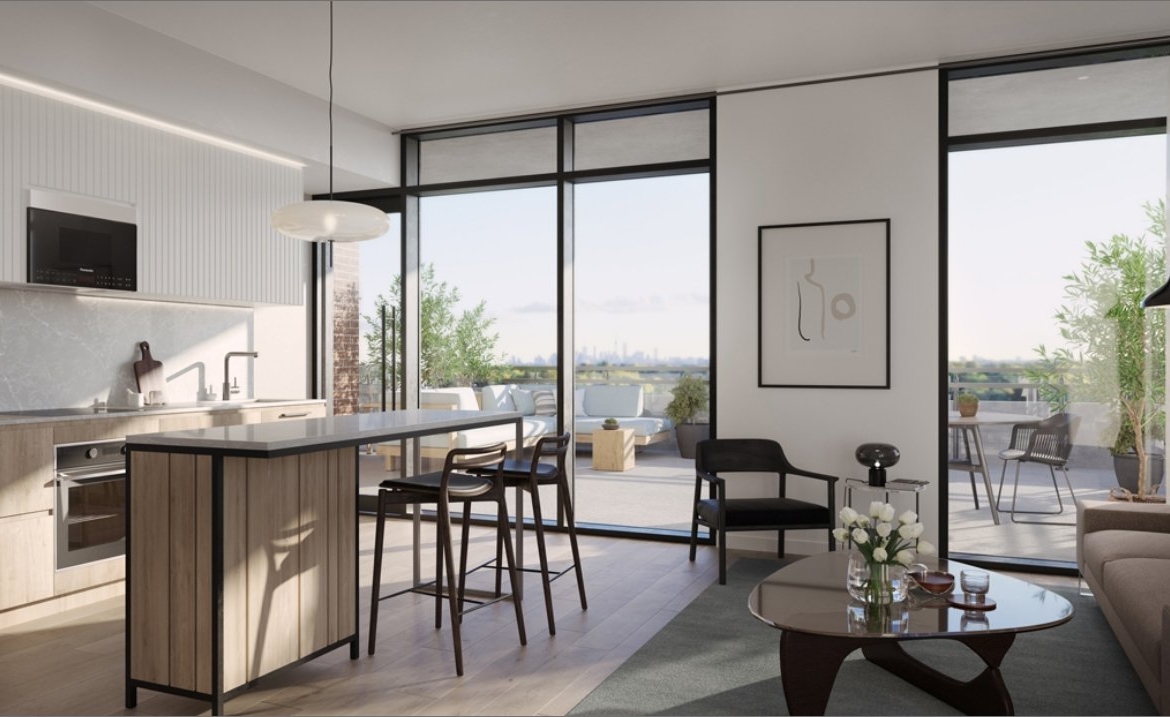 Discover a modern open-concept living space featuring a kitchen island with stools, a cozy sofa, and a coffee table. Large windows lead to a balcony offering breathtaking city views. The decor includes captivating wall art and lush potted plants, perfect for those exploring new condos in the GTA.
