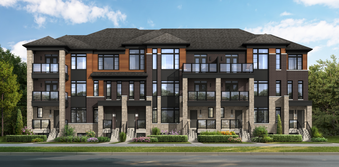 A modern townhouse building with three floors features large windows, brick and wood accents, and multiple entryways. In Brampton's new homes area, the foreground boasts a neatly landscaped garden with shrubs and flowers, set against a clear blue sky.