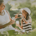A woman and a child enjoy a picnic outdoors, holding drinks and smiling at each other. They are surrounded by greenery, with sunlight filtering through the trees. Text overlays say "South Barrie Towns" and "COMING SOON.