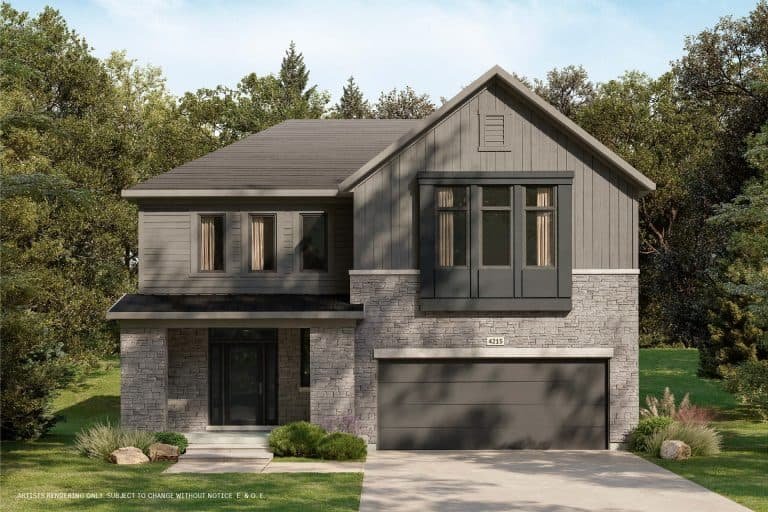 A modern two-story house with gray stone and wood exterior, blending seamlessly into its natural surroundings. It features large windows and a double garage. Nestled in a conservancy, the home is surrounded by a lush green lawn and trees, under a clear blue sky.