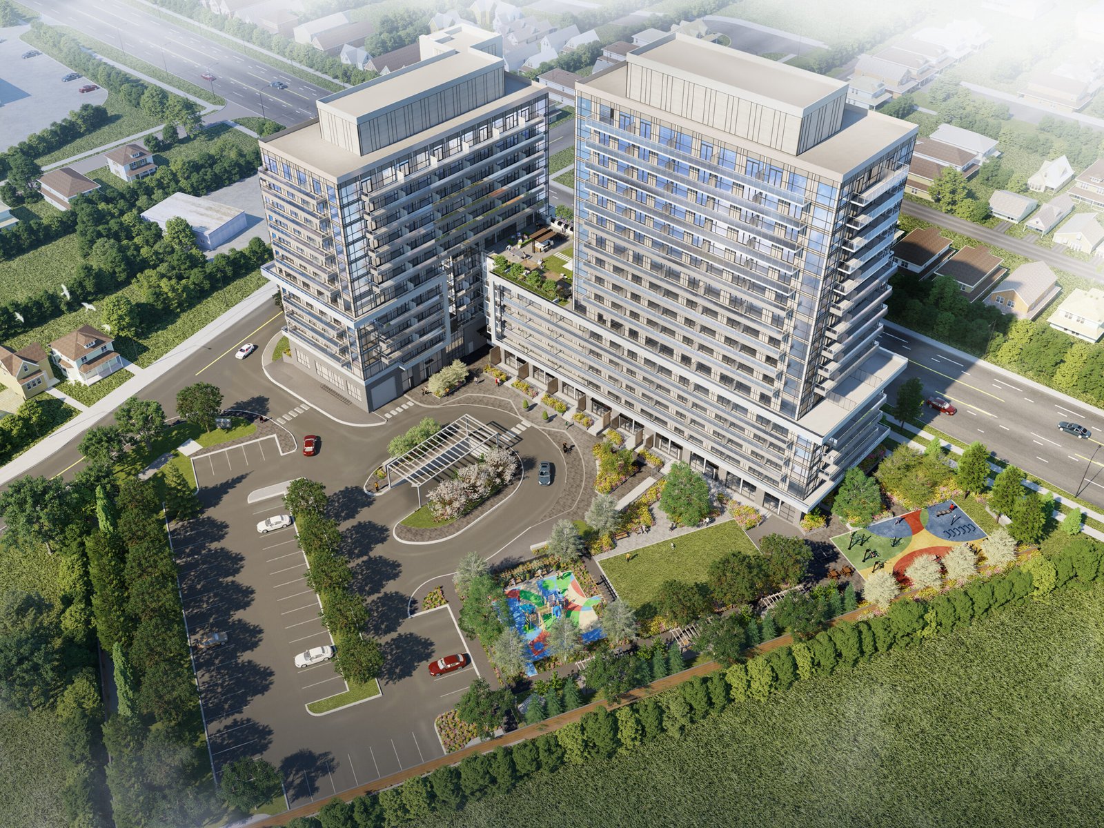 Aerial view of a modern building complex with two tall, adjacent structures and a curved entrance driveway. The area includes a playground, landscaped greenery, and a parking lot, surrounded by roads and residential houses showcasing new homes in Brampton. Aerial view of a modern building complex with two tall, adjacent structures and a curved entrance driveway. The area includes a playground, landscaped greenery, and a parking lot, surrounded by roads and residential houses showcasing new homes in Brampton.