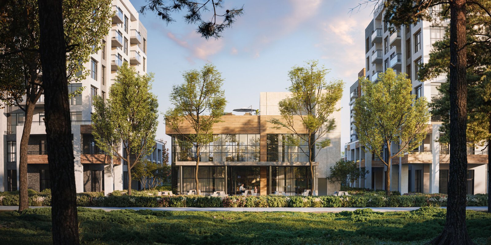 The modern, glass-fronted building, known as Mile & Creek Condos, is surrounded by lush trees and flanked by two towering residential structures. Set under a partly cloudy sky, grass and vibrant plants enhance the scenic foreground.