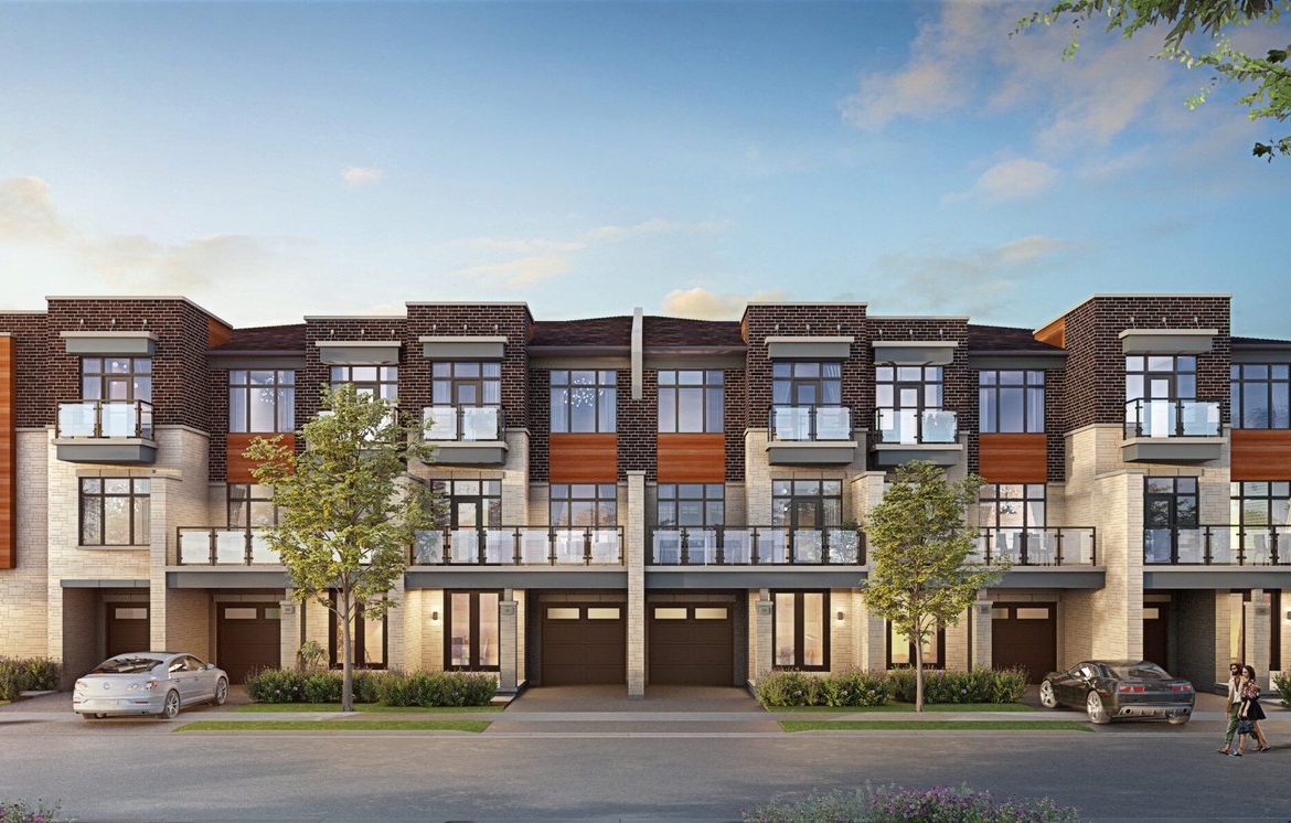 A modern three-story townhouse complex with large windows and balconies features a mix of stone and wood accents. Three cars are parked in front, and a few trees line the street under a clear blue sky. Discover pre-construction homes that offer style and comfort in this picturesque setting.