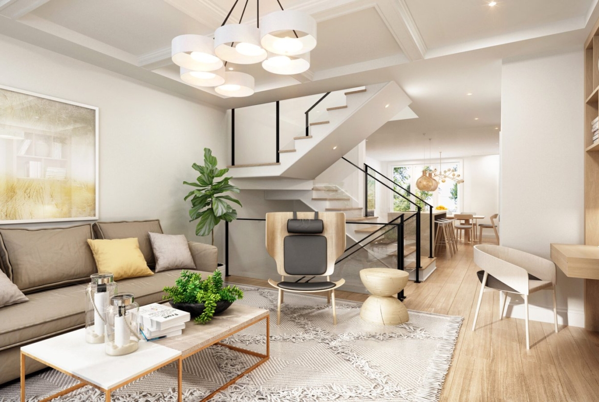 A modern living room features a beige sofa, cushions, and a decor-topped coffee table. A staircase ascends to the upper floor. With a plant, abstract art, wooden furniture, and dining area in the background, this bright space reflects the elegance of new condos in Brampton.