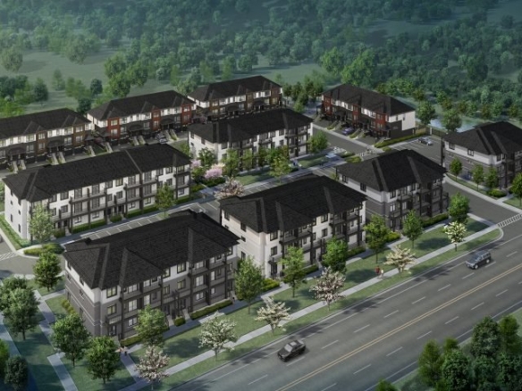 Aerial view of a residential neighborhood featuring new homes in the GTA with rows of modern, multi-story buildings surrounded by trees. A main road runs along the front with cars visible, alongside well-planned green spaces and parking lots.