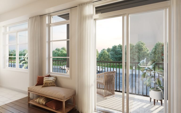 In a bright living space, sliding glass doors open to a balcony with views of green trees, typical of new homes in GTA. Inside, a cushioned bench with pillows and a potted plant by the door enhance the airy atmosphere.
